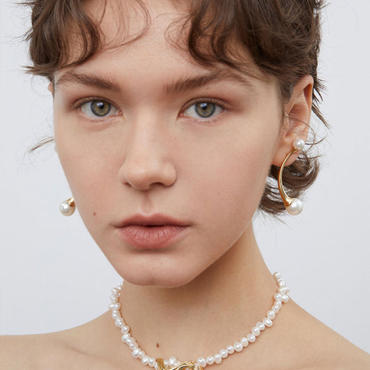 Model wearing TIKOO pearl crawler earrings showing a sophisticated fashion jewelry look.