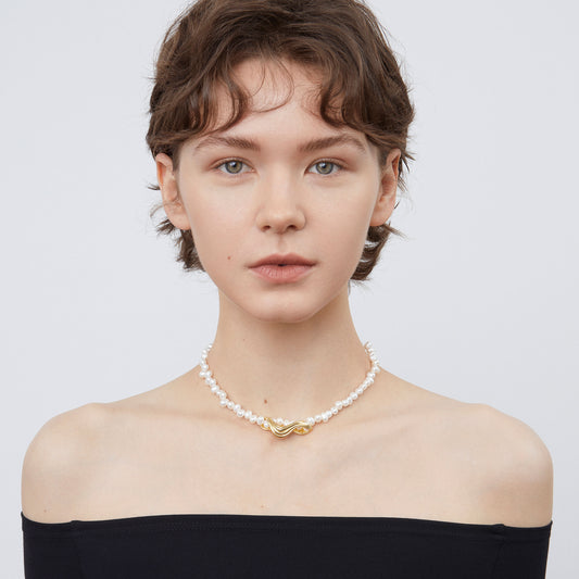 Front view of a model wearing TIKOO handcrafted irregular natural pearl necklace with an off-shoulder black top.