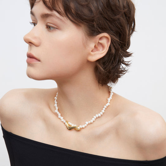 Side profile of a model showcasing the luster and irregular shape of TIKOO natural pearl necklace.