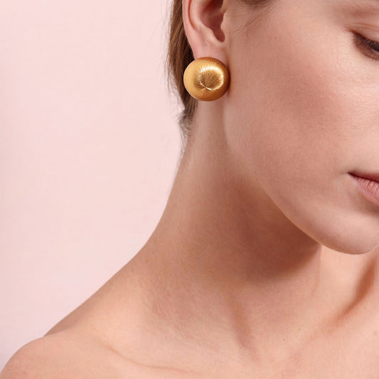 Close-up of TIKOO handcrafted original design brushed gold earrings showing texture