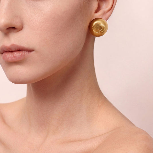Close-up of TIKOO handcrafted original design brushed gold earrings showing texture