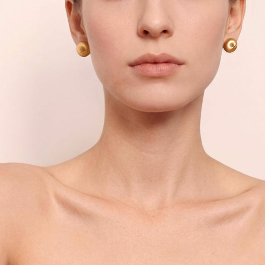 Close-up of TIKOO handcrafted original design brushed gold earrings showing texture