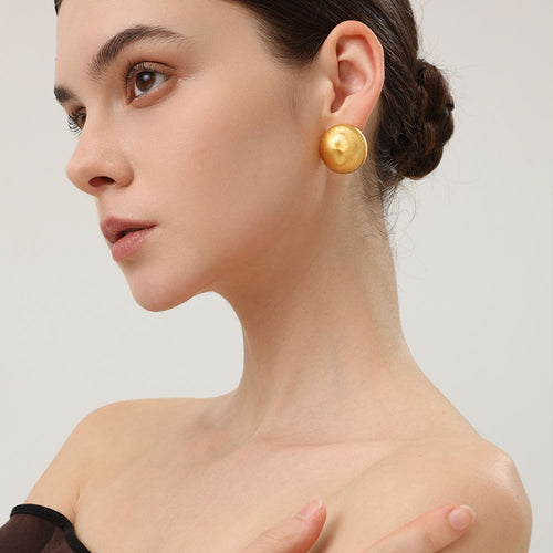 Close-up of TIKOO handcrafted original design brushed gold earrings showing texture