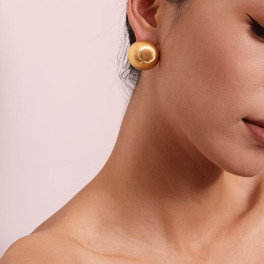 Close-up of TIKOO handcrafted original design brushed gold earrings showing texture