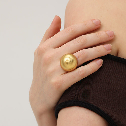 Close-up of a model wearing TIKOO 18K gold brushed dome ring, showcasing bold fashion style.