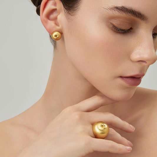 Side view of the thick 18K gold plated dome ring on model, highlighting the quiet luxury aesthetic.