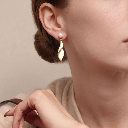 Fashion model styling the TIKOO leaf and pearl drop earrings for a modern, elegant look.