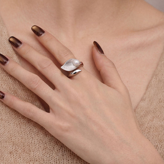 Model wearing TIKOO silver-tone pearl leaf ring with a beige knit sweater for a modern look.