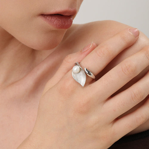 Model wearing TIKOO silver-tone pearl leaf ring with a beige knit sweater for a modern look.

