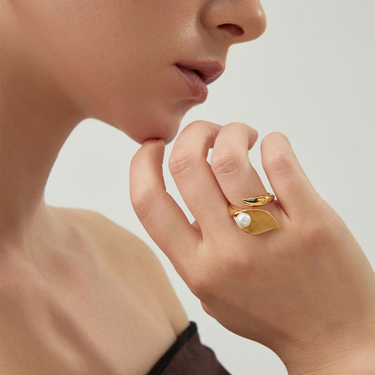 Close-up of a model wearing the TIKOO gold leaf and pearl statement ring with luxury winter fashion.