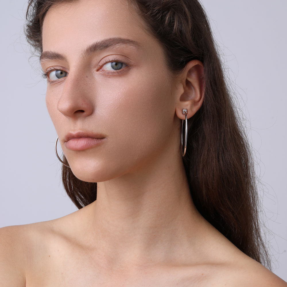 Close-up of TIKOO original design large sterling silver hoops styled with a natural look.