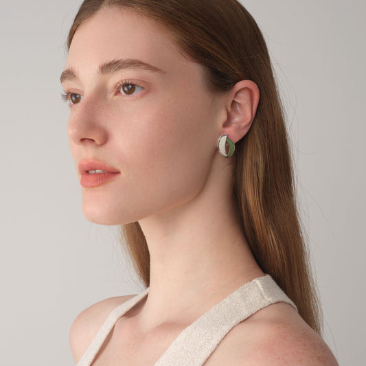 Close-up of TIKOO leaf-shaped leather studs on model, highlighting the textured top-grain leather and thick white gold plating.