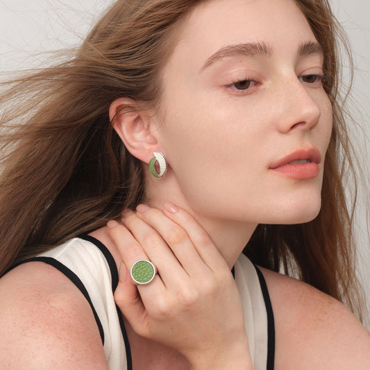 Close-up of TIKOO leaf-shaped leather studs on model, highlighting the textured top-grain leather and thick white gold plating.