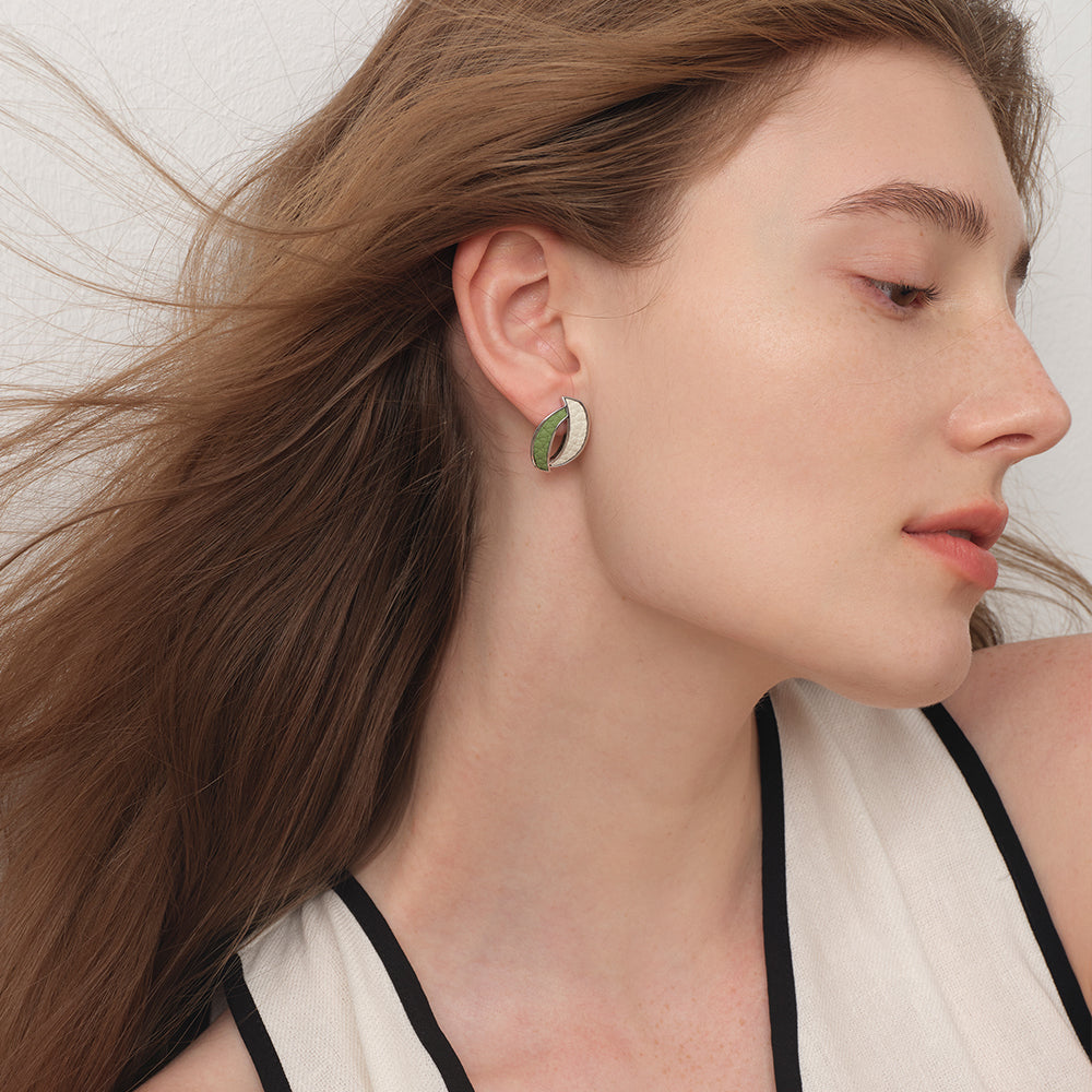 Close-up of TIKOO leaf-shaped leather studs on model, highlighting the textured top-grain leather and thick white gold plating.