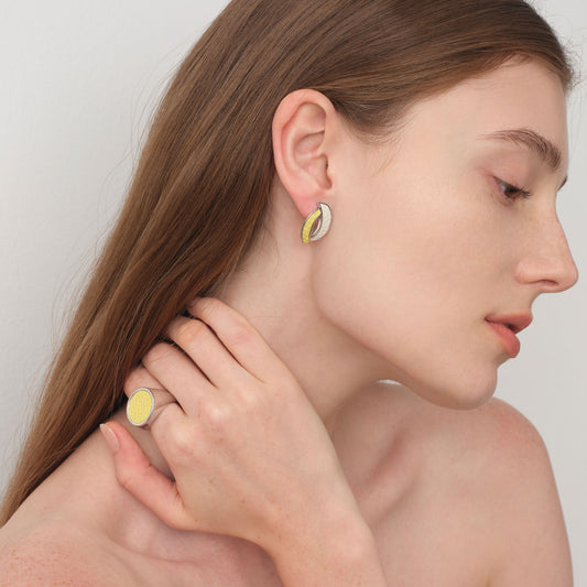 Side view of model wearing TIKOO curved leather studs and matching yellow leather ring, highlighting the textured leather detail.