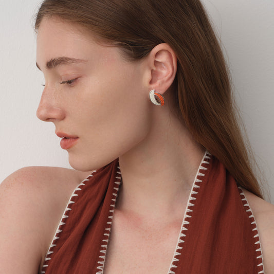 Fashion model wearing TIKOO orange and white leather earrings, showcasing a modern pop-of-color jewelry style.