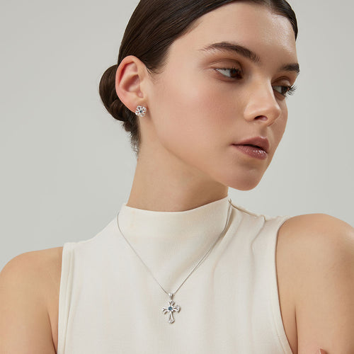 Side view profile of model wearing the TIKOO platinum plated cross pendant and matching studs.