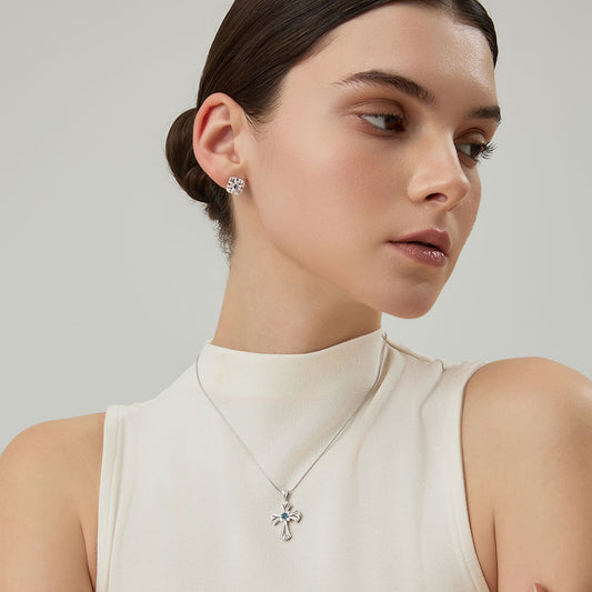 Side view profile of model wearing the TIKOO platinum plated cross pendant and matching studs.