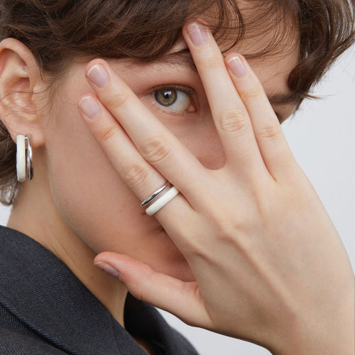 Side view of TIKOO thick platinum-plated white enamel ring showcasing its sculptural lines.