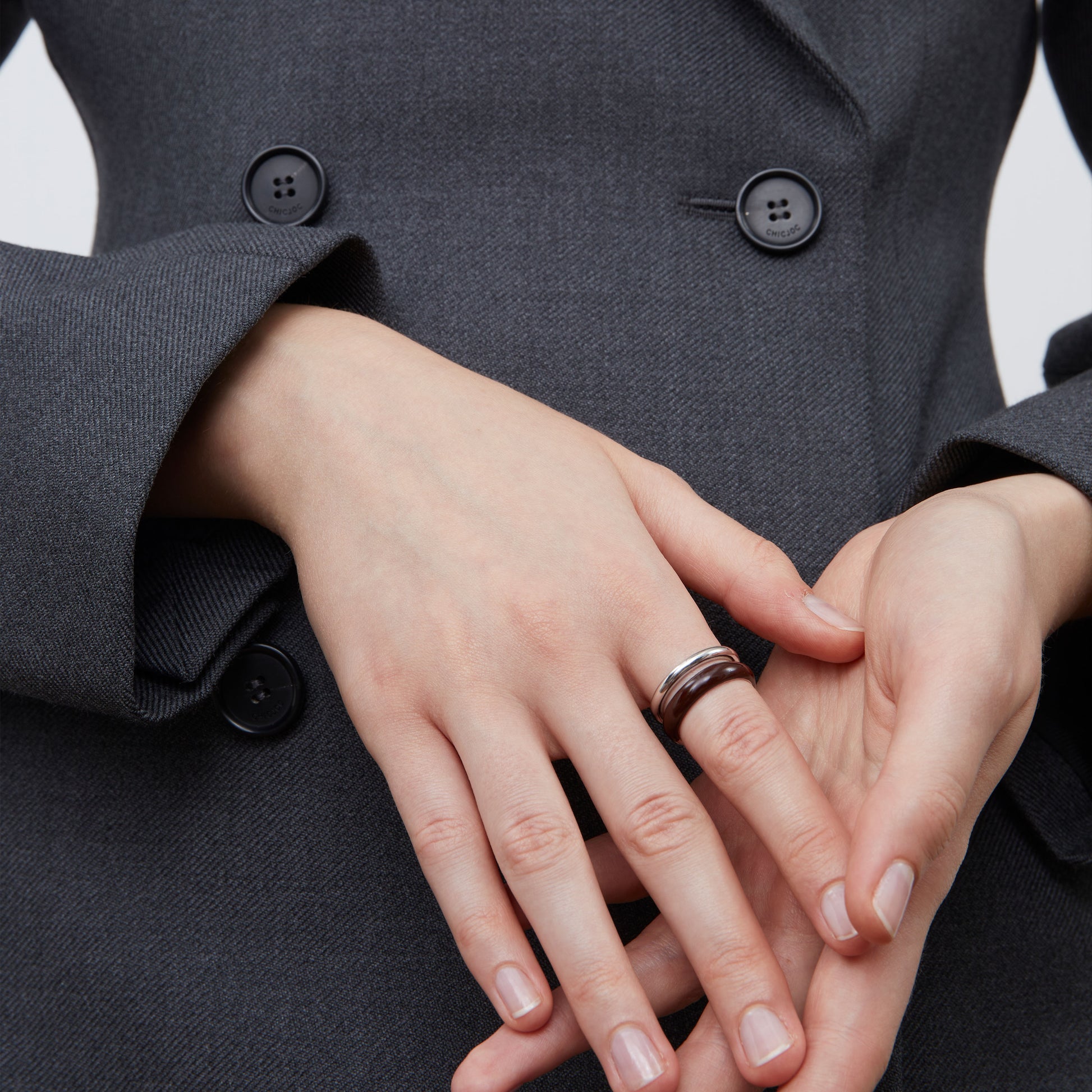 Side view of the TIKOO thick platinum-plated brown enamel ring showcasing its sculptural lines.
