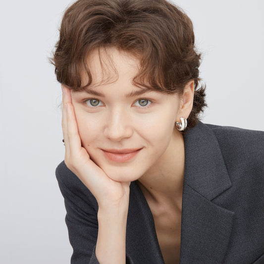 Side profile of a model showcasing the architectural layers of TIKOO white enamel hoop earrings.