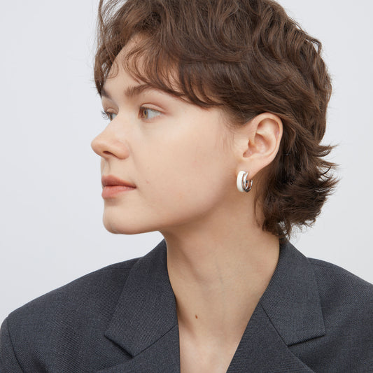 Portrait view of a model showcasing TIKOO original white enamel earrings for a professional look.