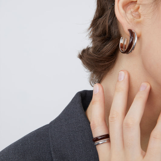 Side view of a model wearing TIKOO architectural double-layer espresso brown enamel earrings.