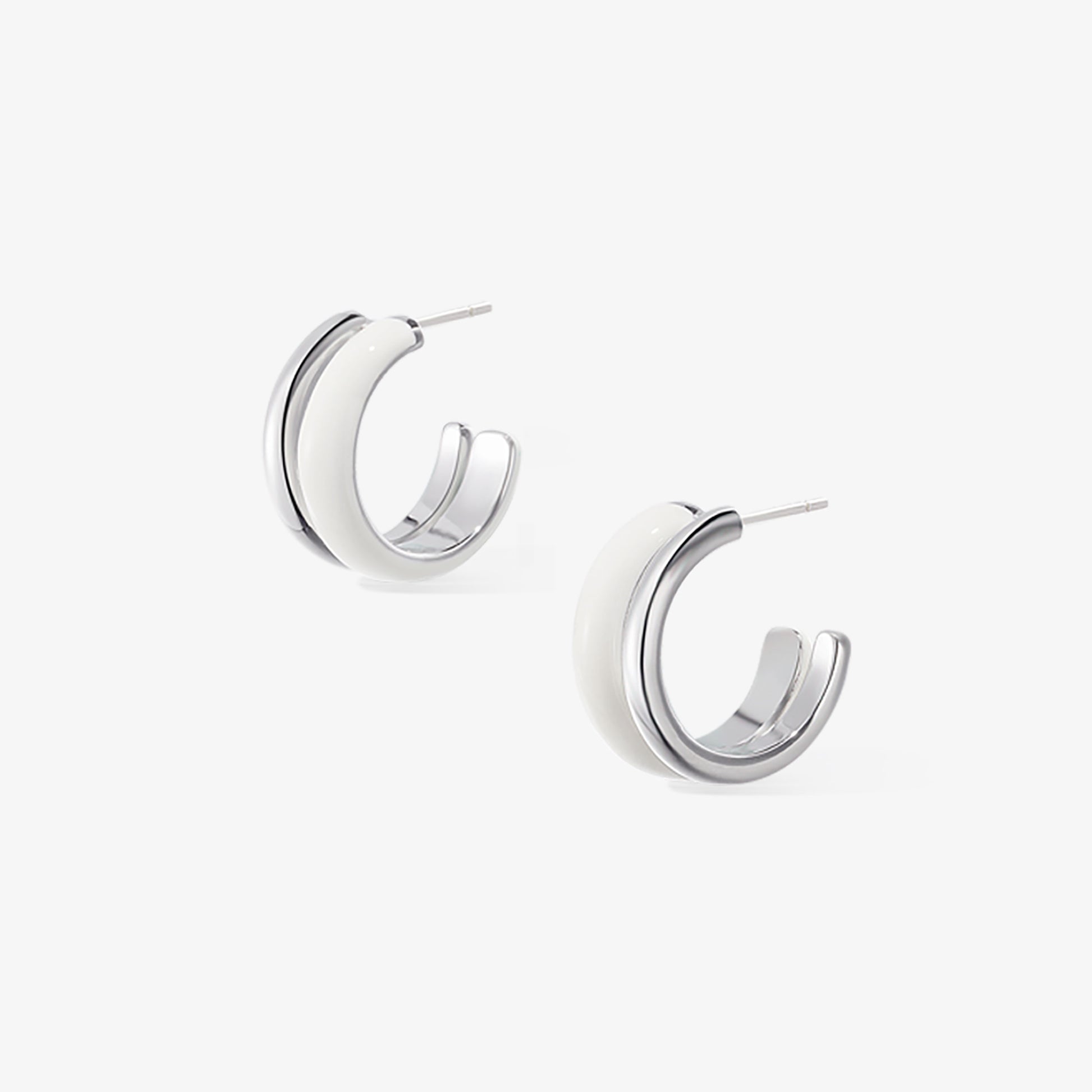 Detailed view of handcrafted TIKOO white enamel and platinum-plated double-layer earrings.
