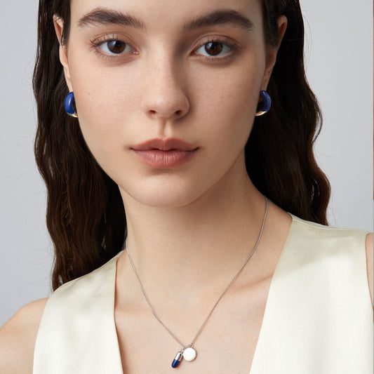 Front view of a fashion model wearing TIKOO minimalist deep blue enamel earrings, showcasing a modern jewelry look.