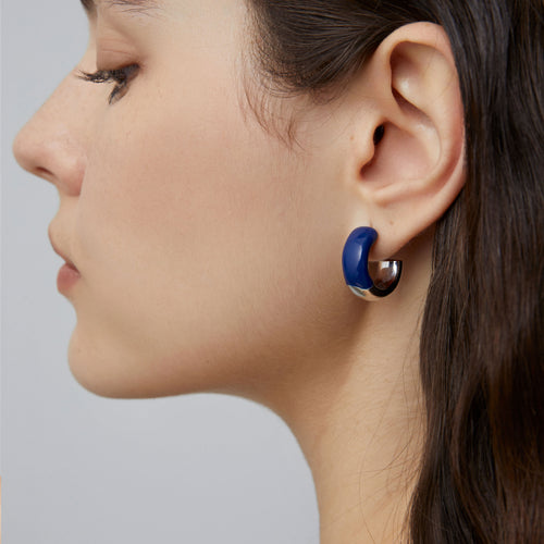 Detailed side profile of a model wearing TIKOO eco-friendly copper earrings with blue enamel and silver-tone platinum finish.