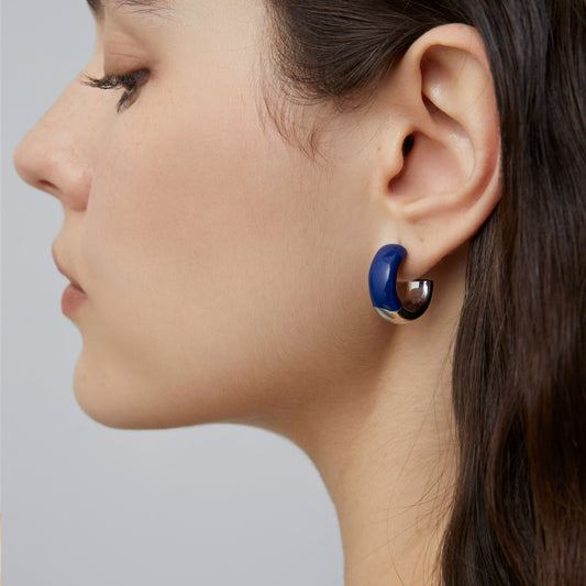 Detailed side profile of a model wearing TIKOO eco-friendly copper earrings with blue enamel and silver-tone platinum finish.