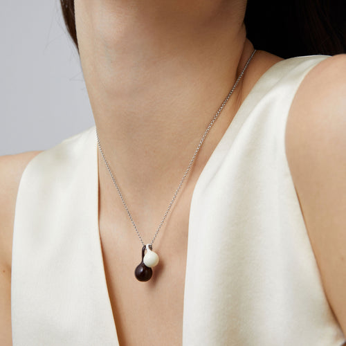 Macro detail of the brown and white enamel gourd charms on a high-quality platinum-plated chain from TIKOO.