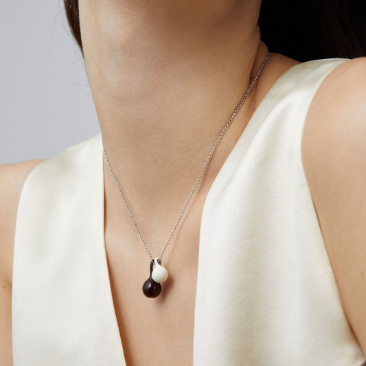 Macro detail of the brown and white enamel gourd charms on a high-quality platinum-plated chain from TIKOO.