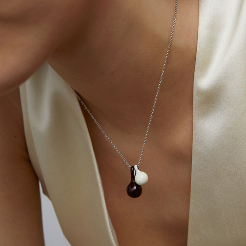 Macro detail of the brown and white enamel gourd charms on a high-quality platinum-plated chain from TIKOO.