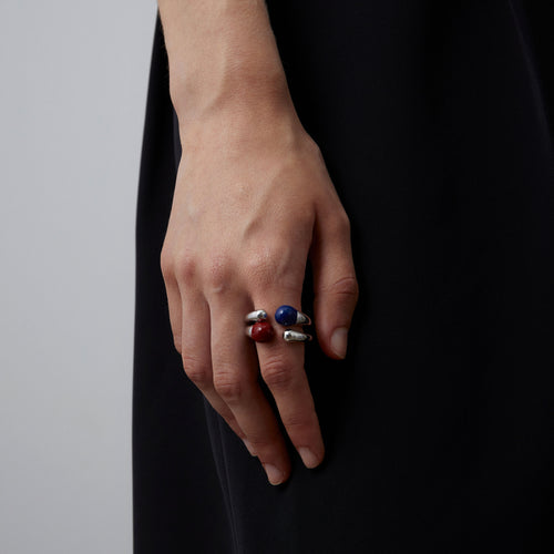 A fashion model showcasing how to stack TIKOO organic enamel rings in deep blue and red for a modern jewelry look.