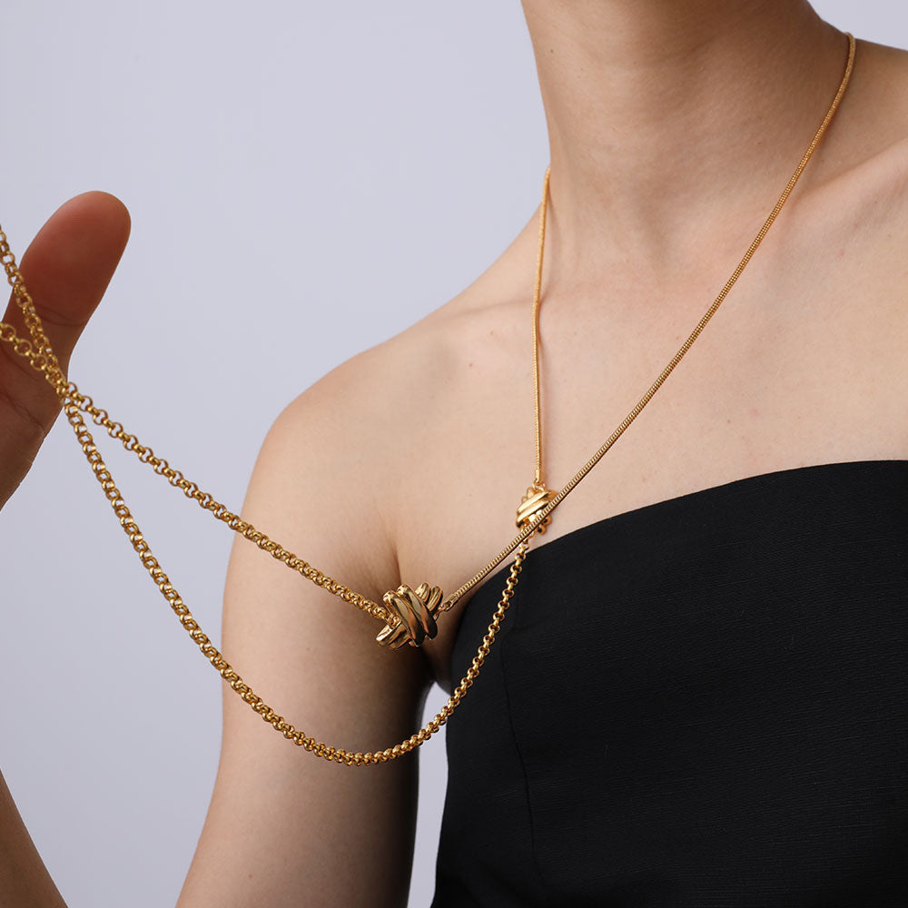 Close-up shot of the TIKOO multi-chain gold necklace highlighting the intertwined knot motifs and chain textures.