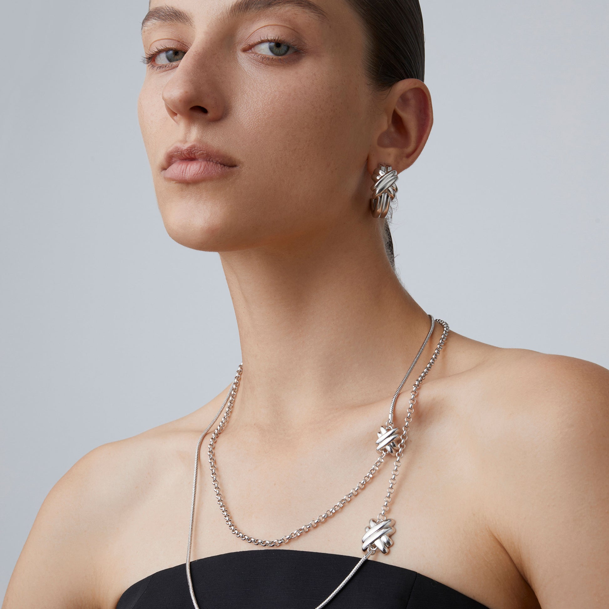 Close-up of the doubled-up layered effect of the TIKOO long knot necklace highlighting the asymmetric chain textures.