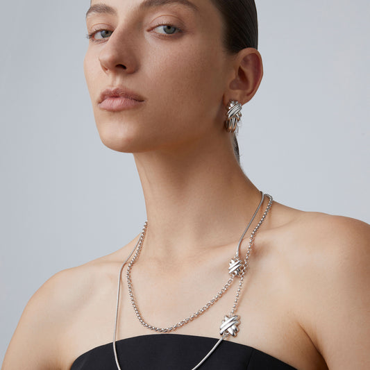 Close-up of the doubled-up layered effect of the TIKOO long knot necklace highlighting the asymmetric chain textures.