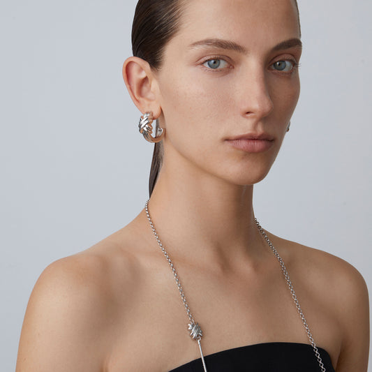 Side profile of TIKOO's statement knot earrings showing the intricate sculptural detail.