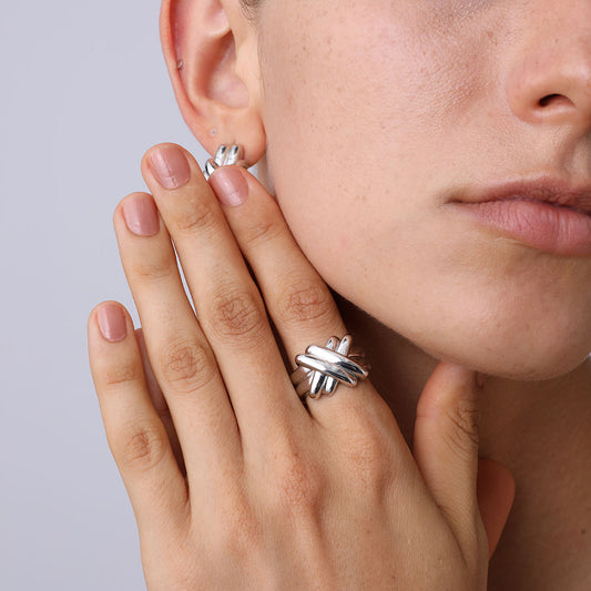 Close-up of the intertwined texture of the 925 sterling silver ring on a model's hand.