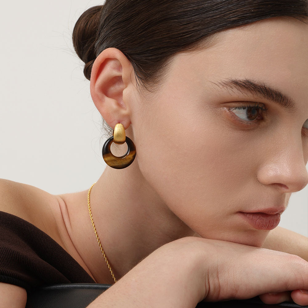 Close-up of a model wearing TIKOO tiger eye stone hoop earrings, showcasing the quiet luxury and old money style.