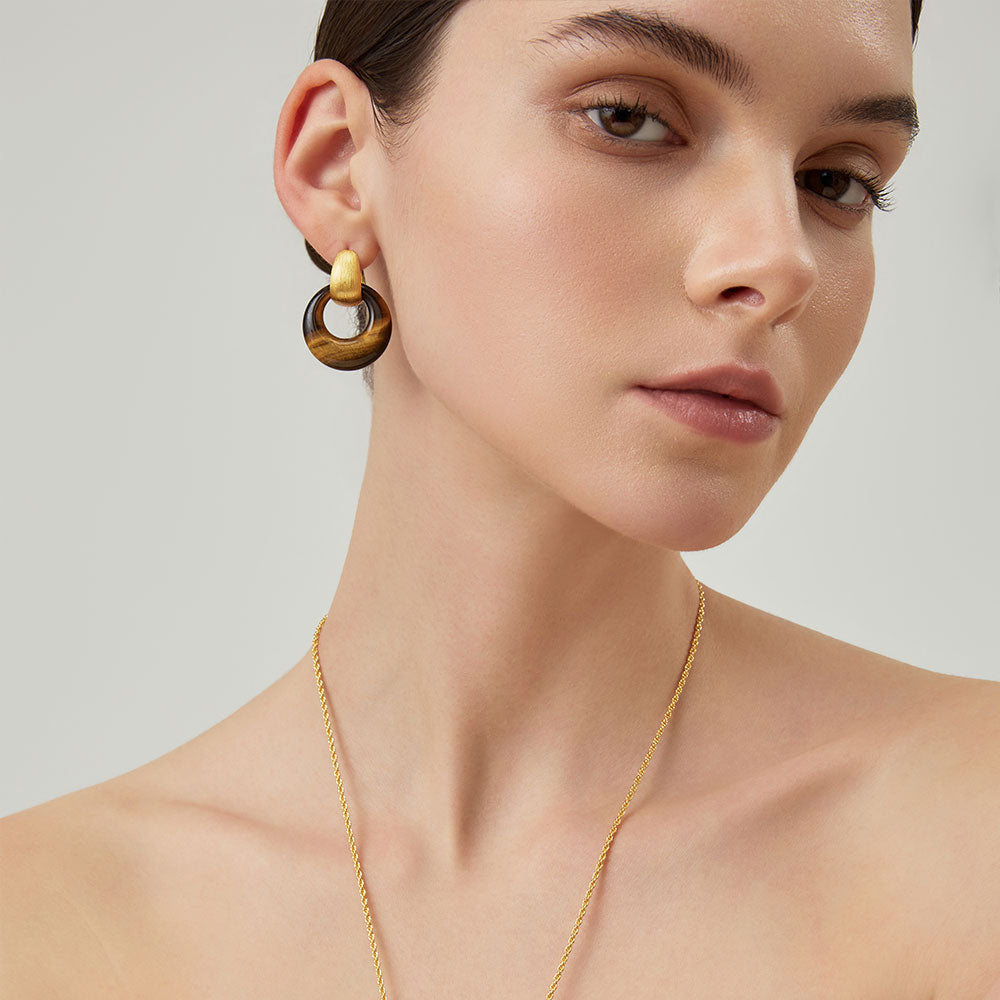 Detailed view of the chatoyant brown tiger eye texture and 18k gold plated finish on TIKOO designer earrings.
