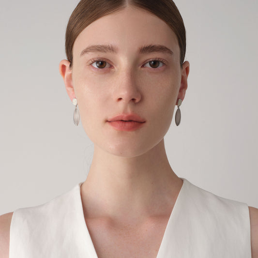 Front view of a model wearing TIKOO white stone and leather drop earrings, showcasing the elegant and clean minimalist look.