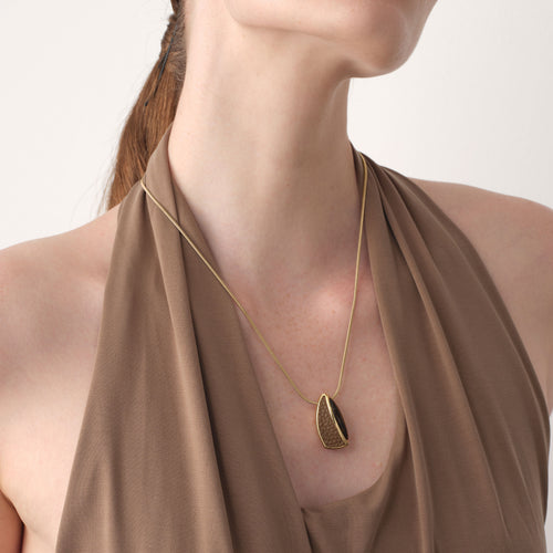 Close-up of TIKOO thick 18K gold plated pendant on a model, highlighting the unique leather texture and natural stone.