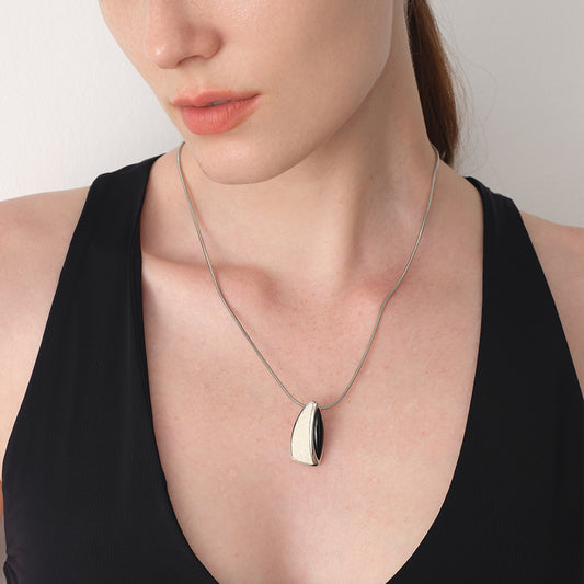 Model wearing TIKOO original black onyx and leather necklace on a black tank top, showcasing its fluid design.