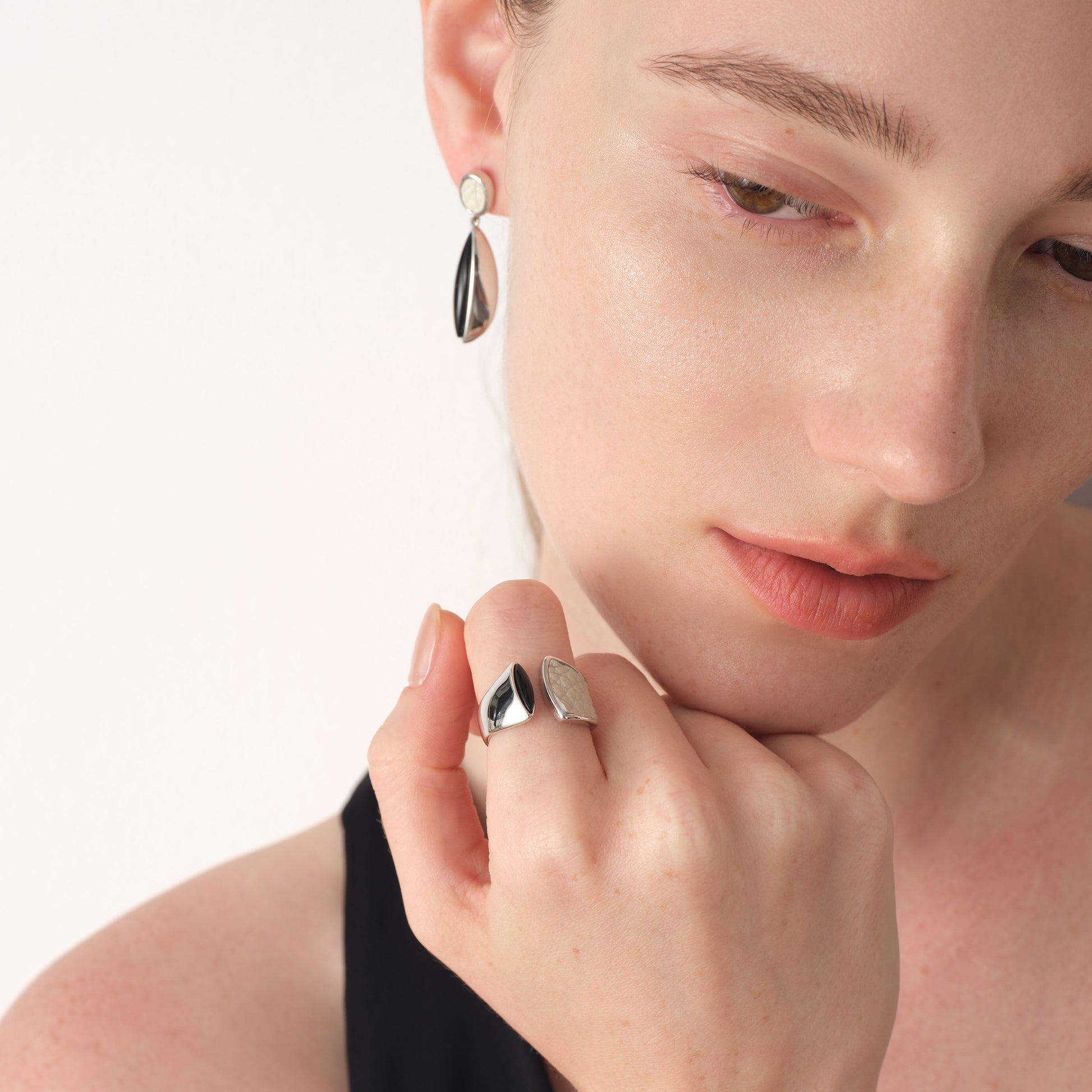 Model showcasing the fluid architectural design of TIKOO's black and white mixed-material open ring.