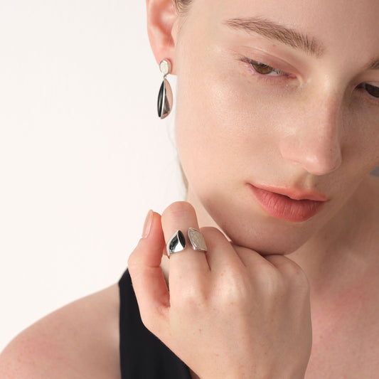 Model showcasing the fluid architectural design of TIKOO's black and white mixed-material open ring.