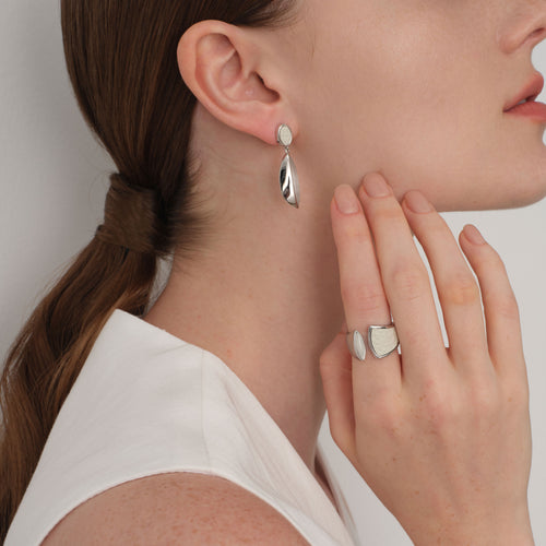 Lifestyle shot of TIKOO white leather and gemstone ring paired with matching drop earrings for a complete modern aesthetic.