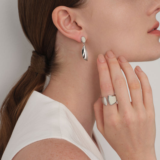 Lifestyle shot of TIKOO white leather and gemstone ring paired with matching drop earrings for a complete modern aesthetic.