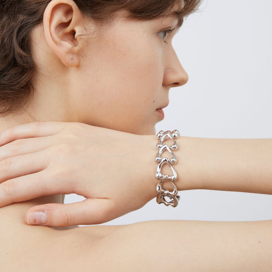 Detailed macro view of the interlocking fluid heart links on the TIKOO platinum plated eco-copper bracelet.